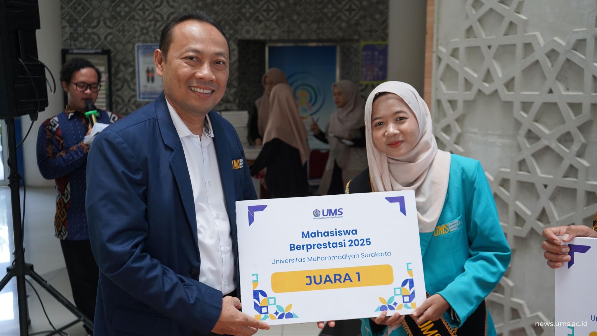 Wakil Rektor I UMS Prof. Ihwan Susila, S.E., M.Si., Ph.D. memberikan piagam penghargaan kepada Samiyem, juara pertama dalam Pemilihan Mahasiswa Berprestasi.