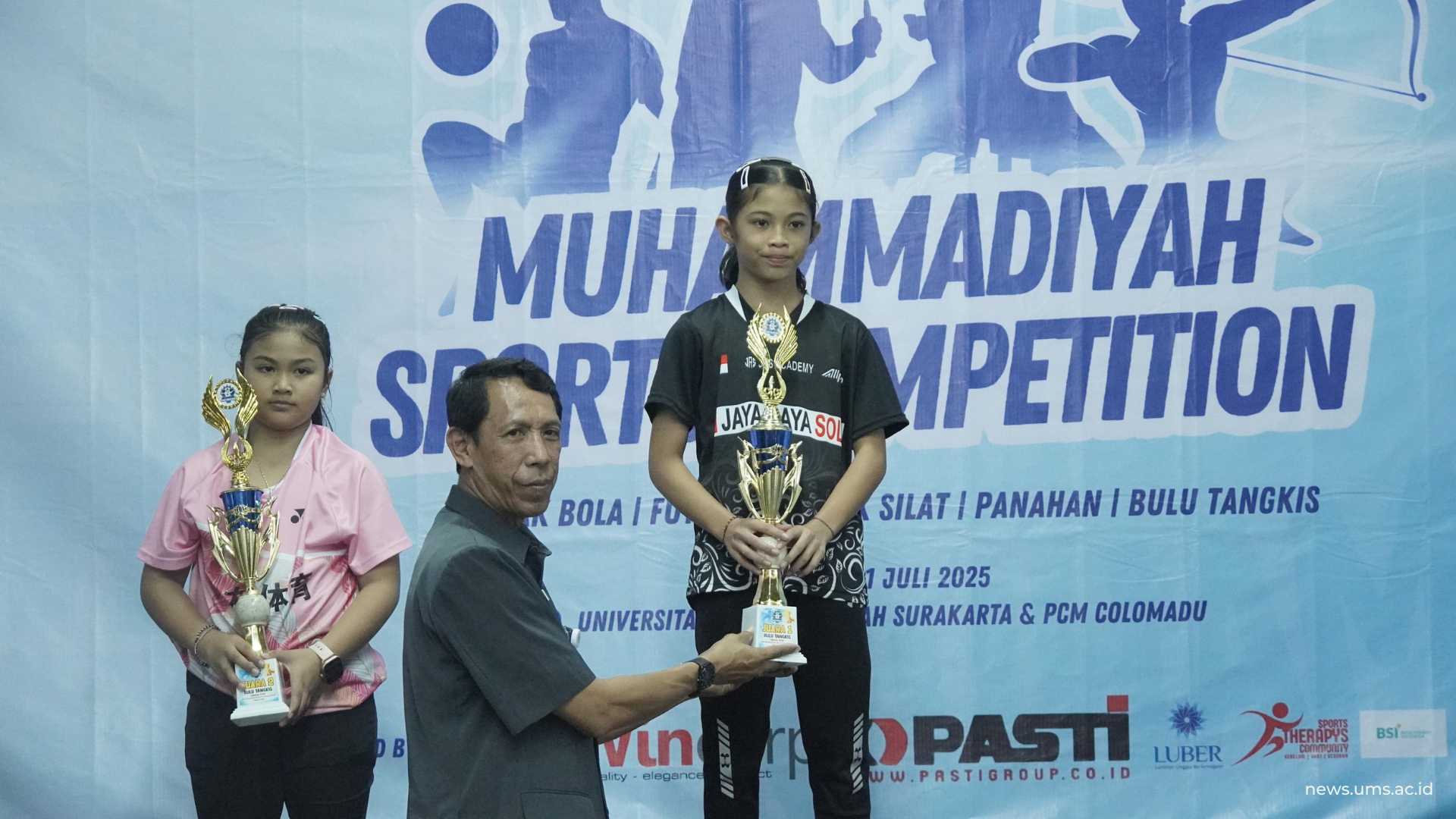 Ketua PBSI Colomadu Heru Nugroho, M.Pd. tengah memberikan piala kepada juara pertama tunggal putri.