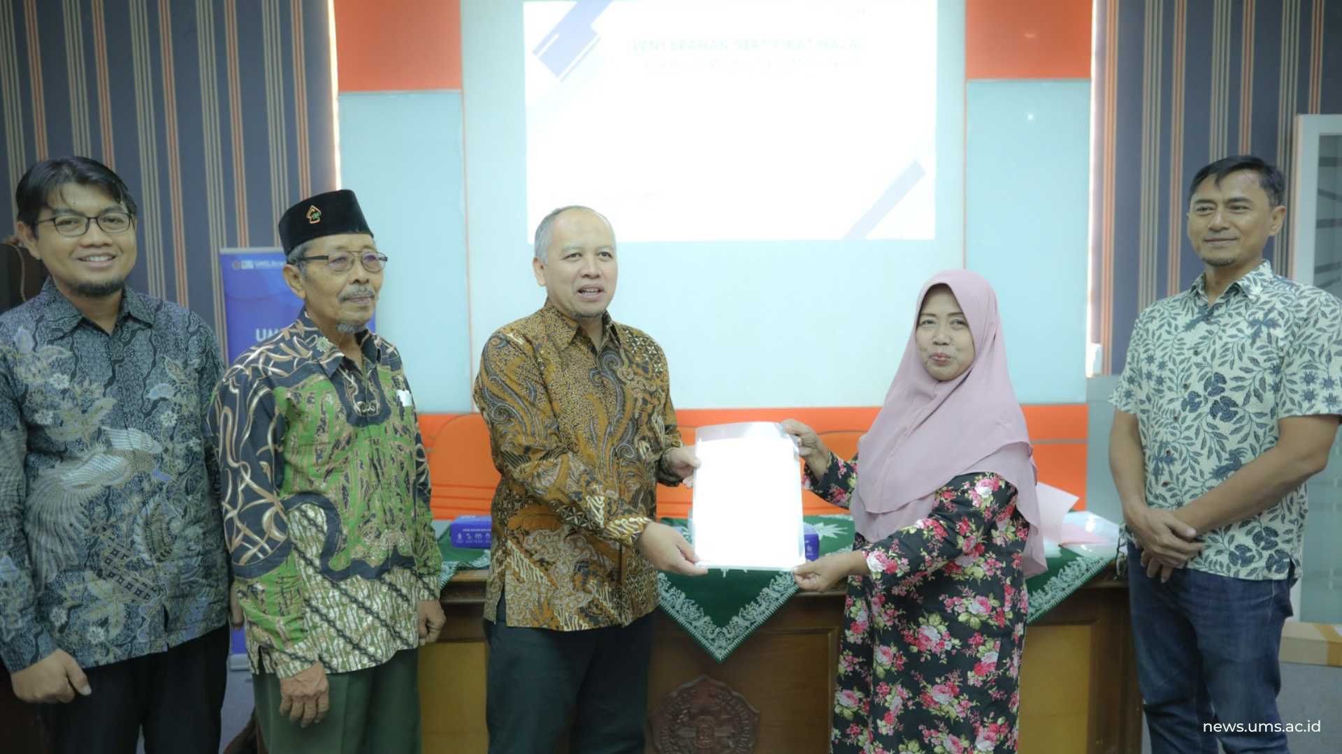 Dari kiri, apt. Peni Indrayudha, M.Biotech., Ph.D., K.H. Drs. Subari, Prof. Dr. apt. Muhammad Da’i, M.Si., menyerahkan sertifikat halal secara simbolis kepada perwakilan UMKM mitra usaha UMS Boga. Humas UMS/Luqman Hakim