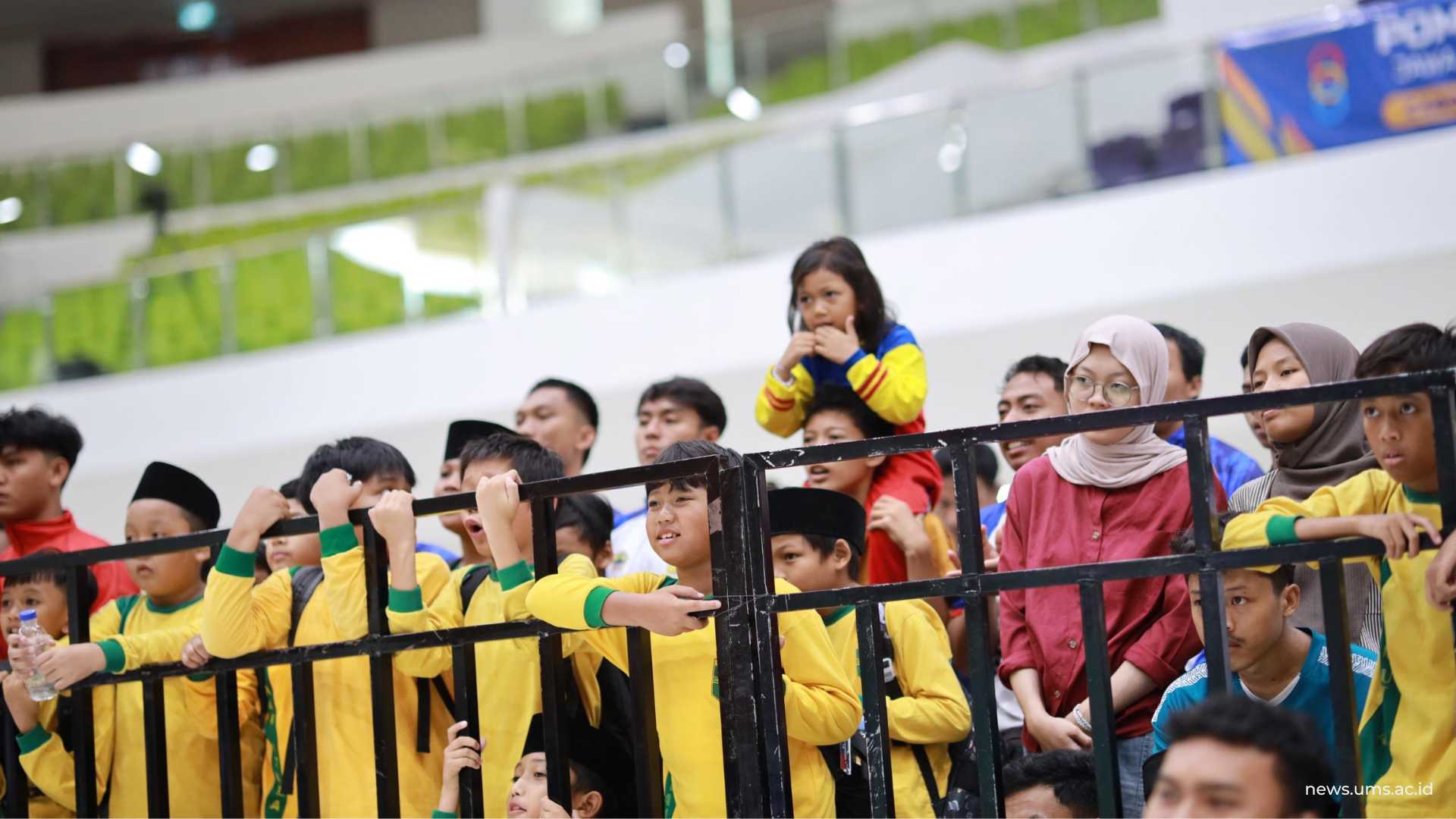 Sejumlah murid SD Djama’atul Ichwan Program Unggulan Surakarta yang menonton pertandingan pencak silat POMNAS XIX 2025 di Edutorium UMS, 25 September 2025.