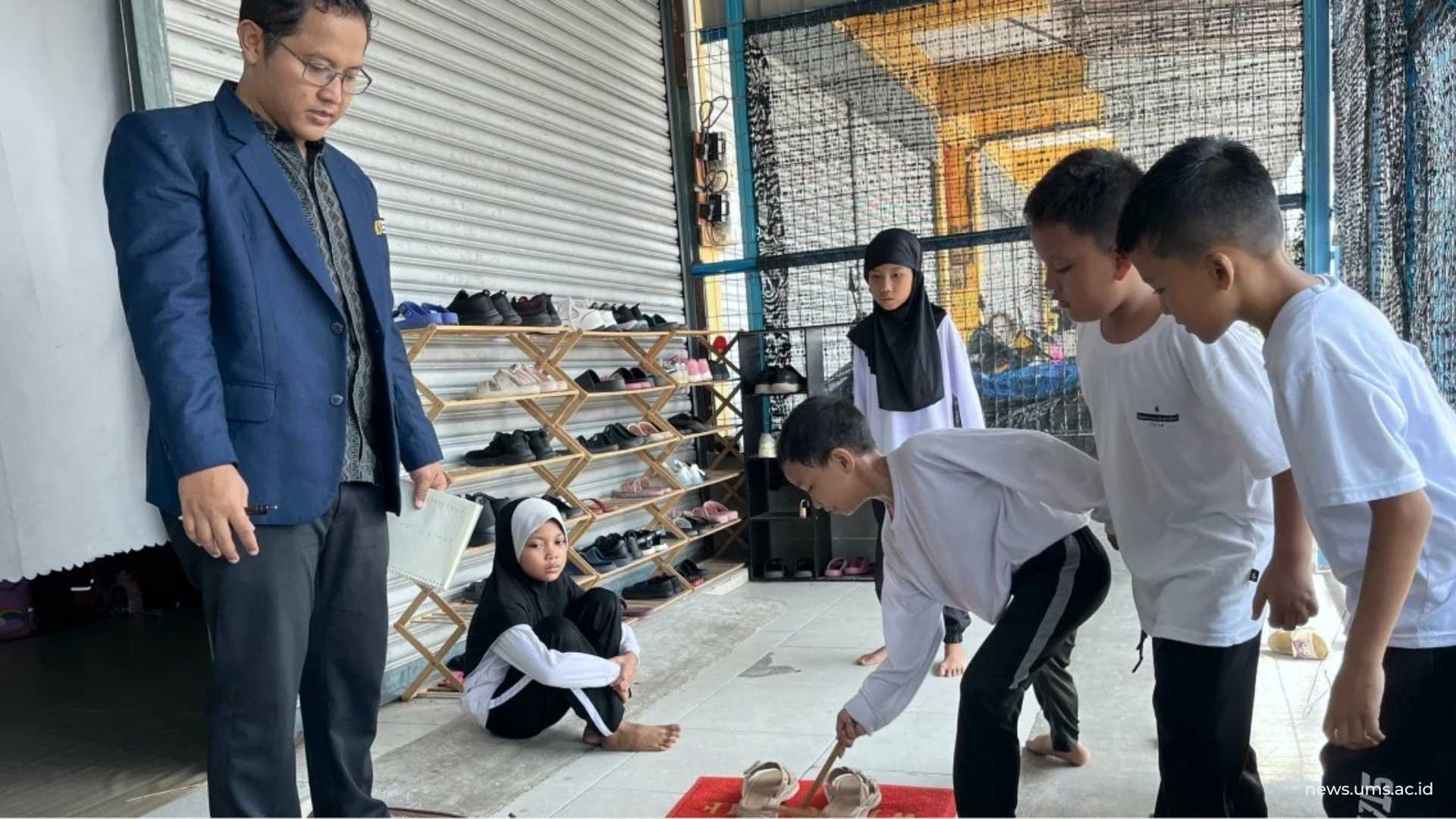 Ketua tim pengabdian Naufal Ishartono, Ph.D. mendampingi siswa SD Sanggar Belajar Sungai Buloh saat mempraktikkan permainan tradisional Indonesia dalam pembelajaran matematika. Dok.Pribadi