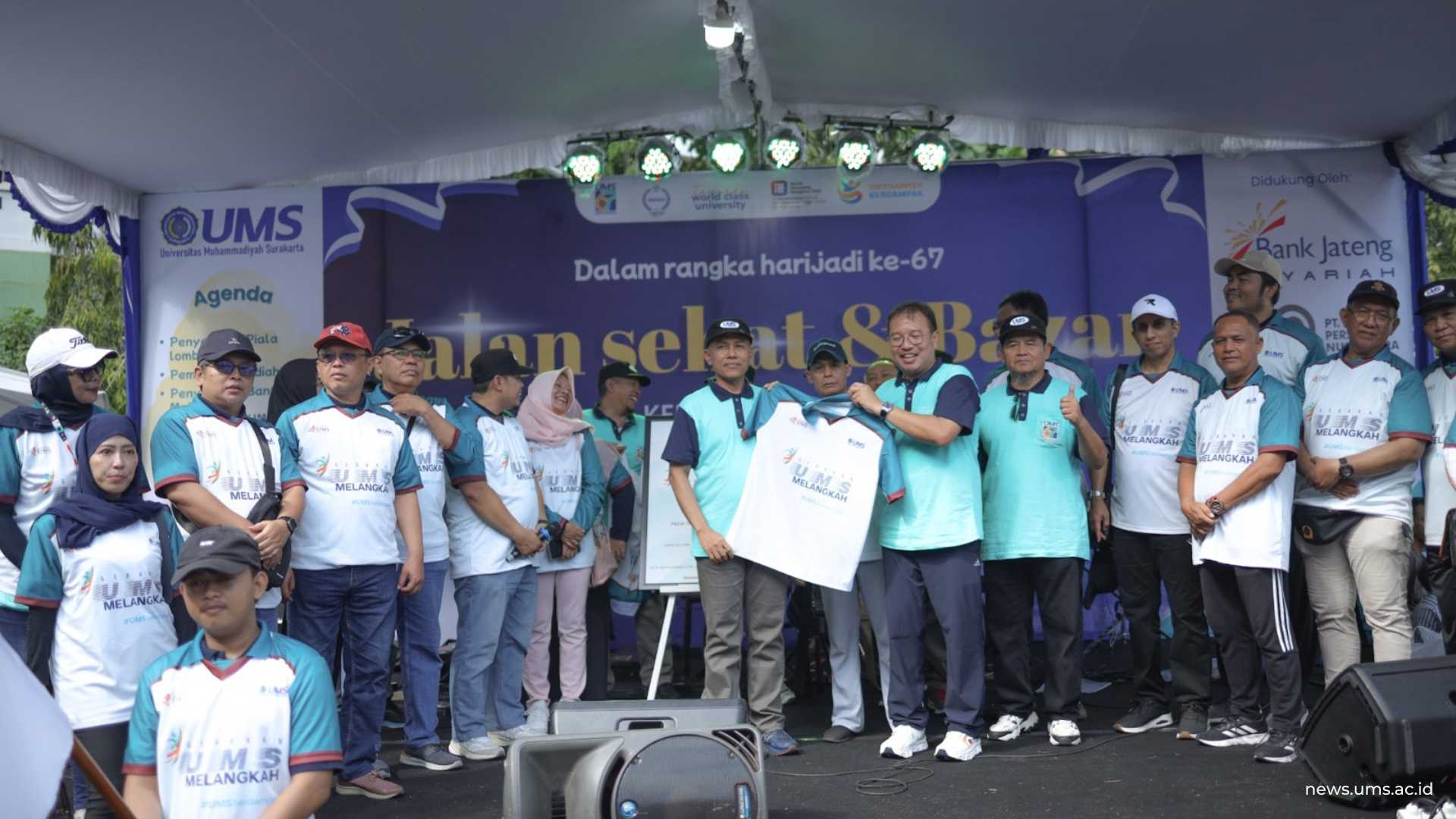 Ketua IKA UMS Dr. M. Aditya Warman, S.Psi., M.B.A. menyerahkan kaus simbolis Gerakan UMS Melangkah Berdampak kepada Rektor UMS Prof. Dr. Harun Joko Prayitno, M.Hum. sebagai tanda kolaborasi alumni dan kampus. Luqman Hakim/Humas UMS