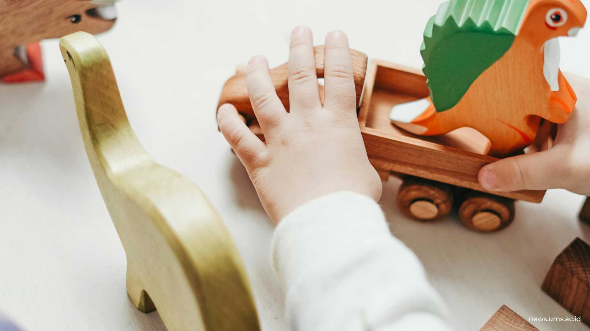 Anak kecil yang memegang patung hewan kayu coklat (Foto: cottonbro studio/pexels)