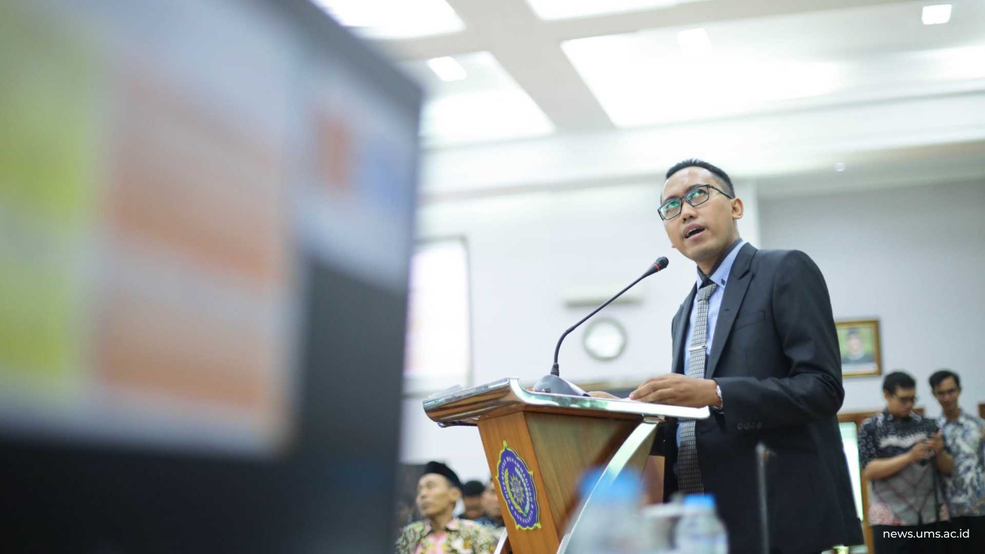 Husni Mubarok saat memaparkan disertasinya di hadapan para penguji sidang di Auditorium Moh. Dzajman UMS. Humas UMS/Luqman Hakim